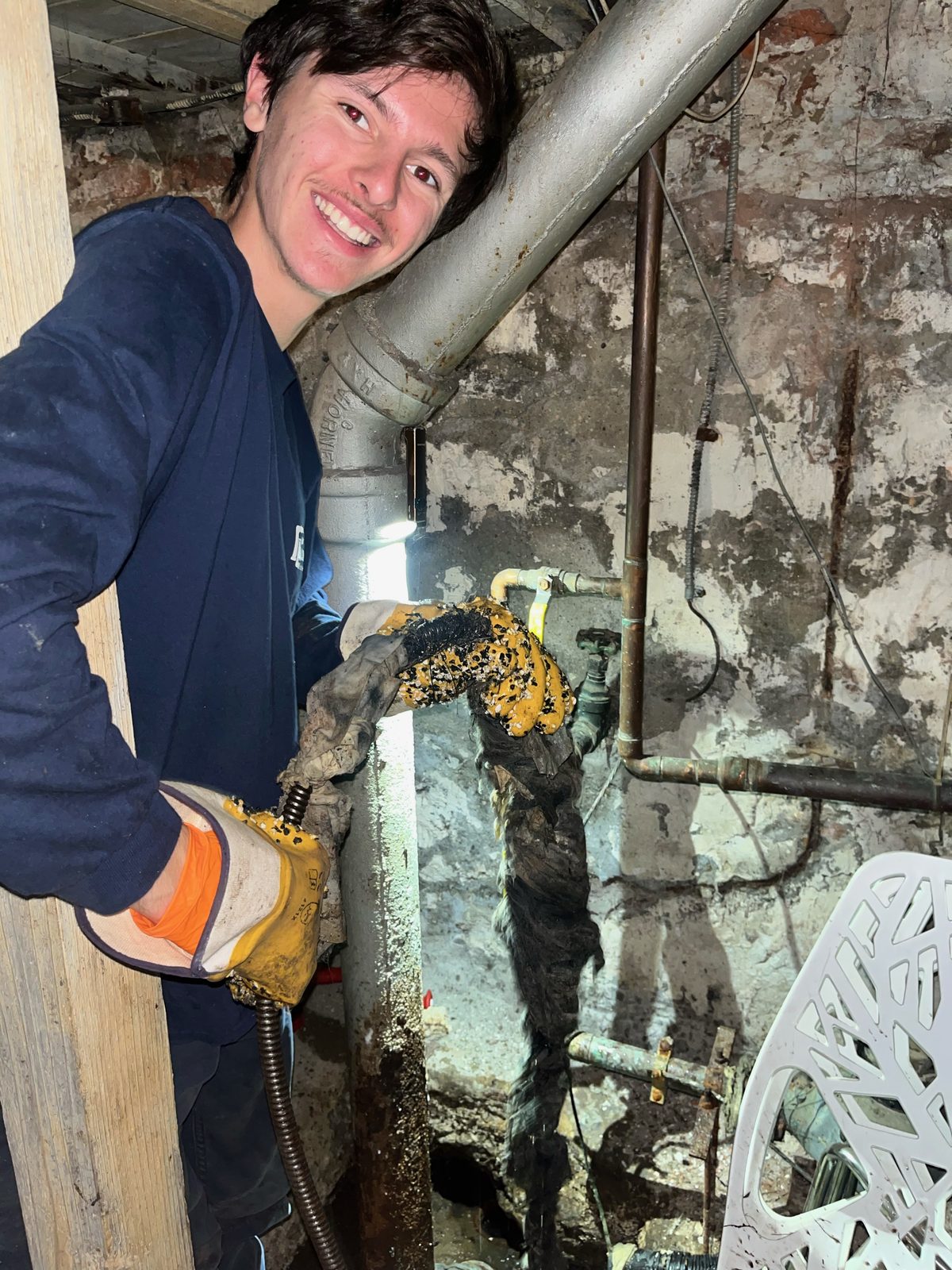 Sewers R Us plumber clearing a cast iron soil stack in a New York City basement.